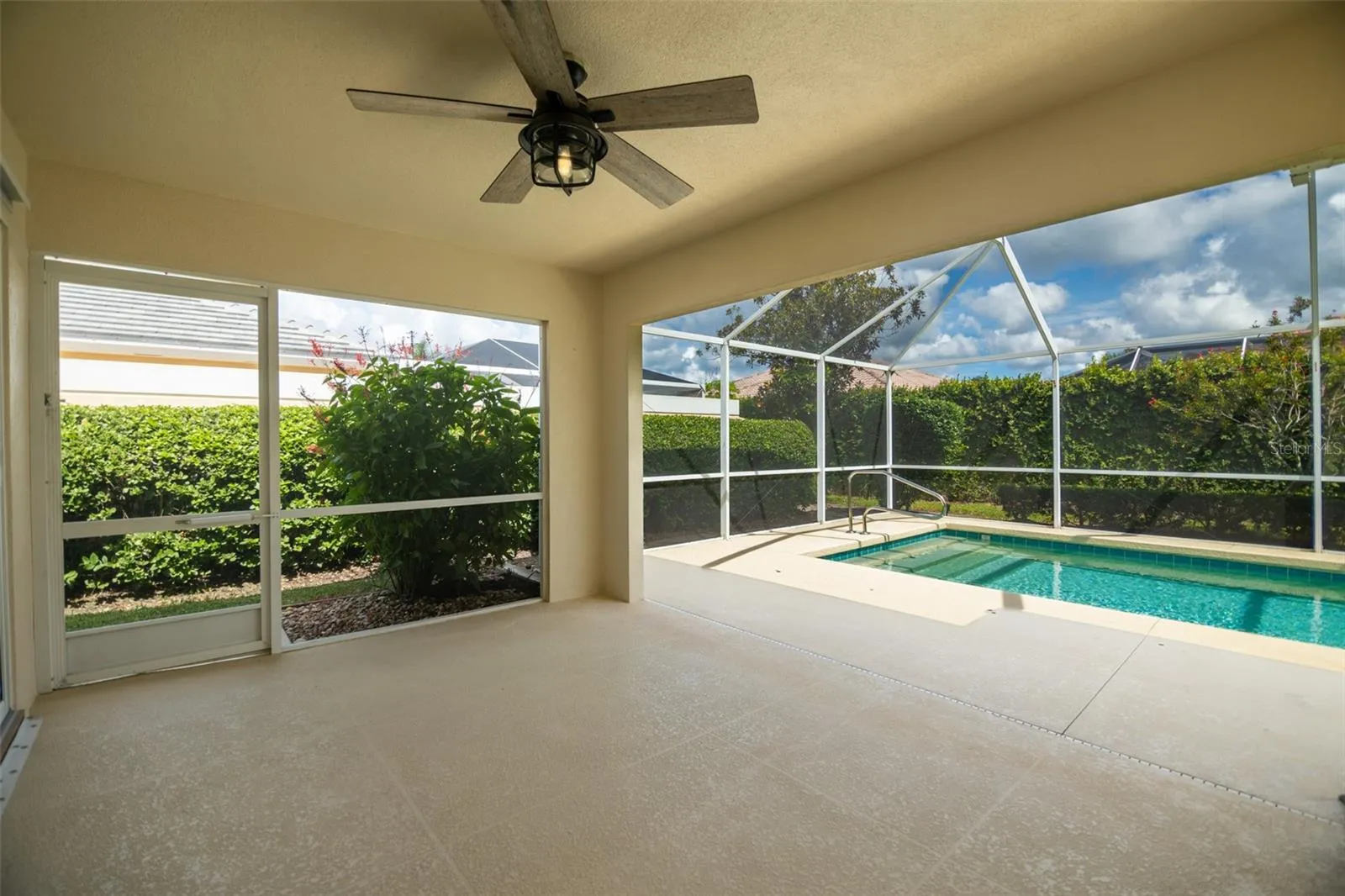 Back patio screen door on left with view of the pool on the right.