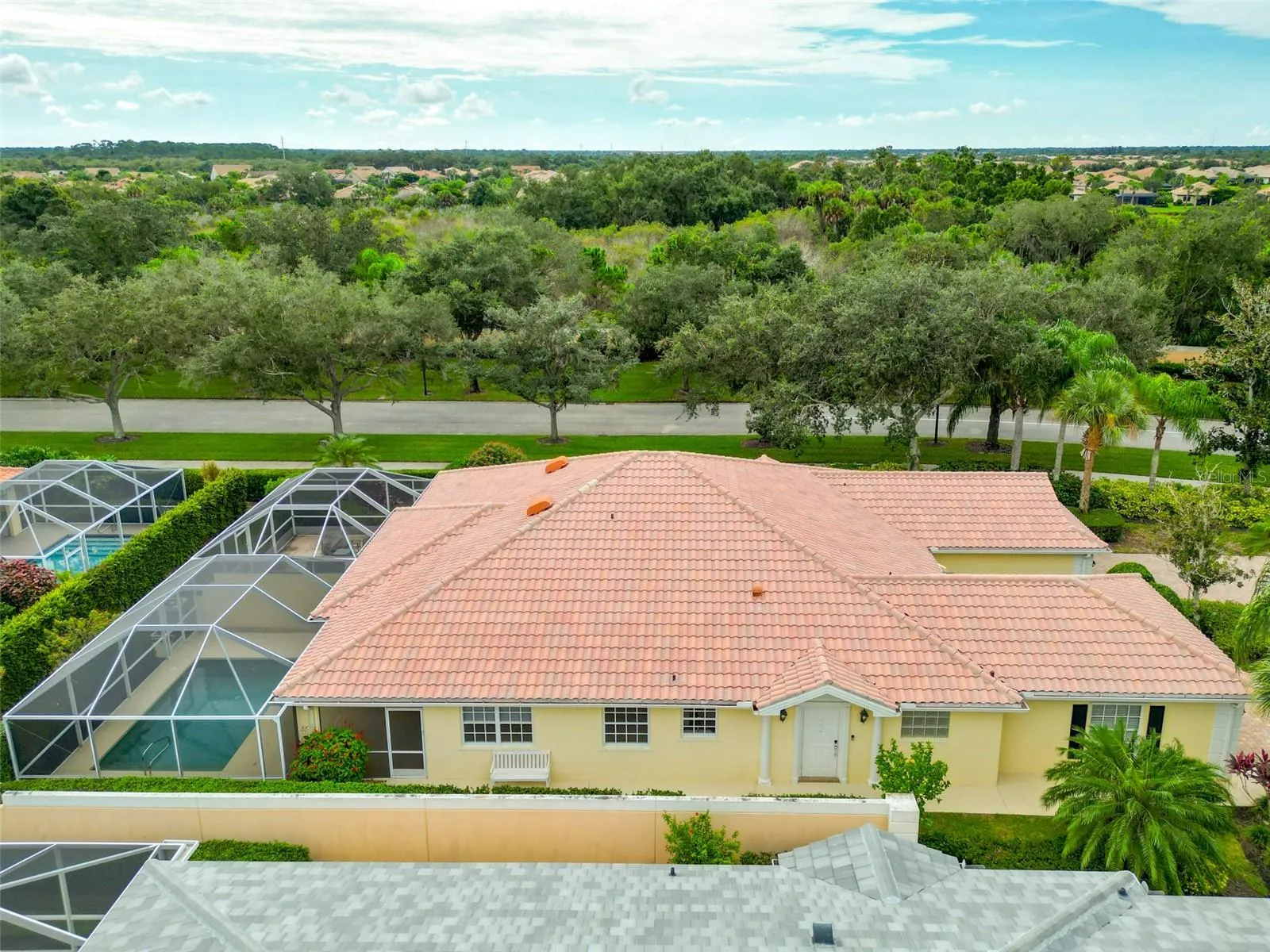 Overhead view of side of home with walk way to front door and pool area.