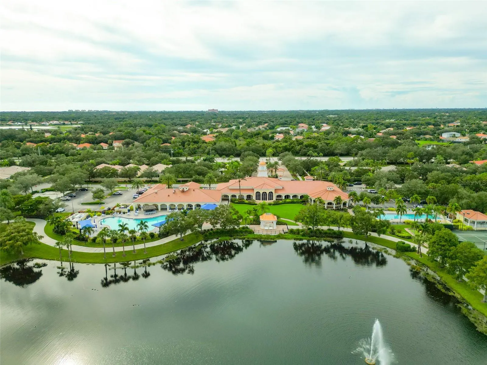 Community center with view of both a lagoon and lap pool with the community center and gazebo in the middle.