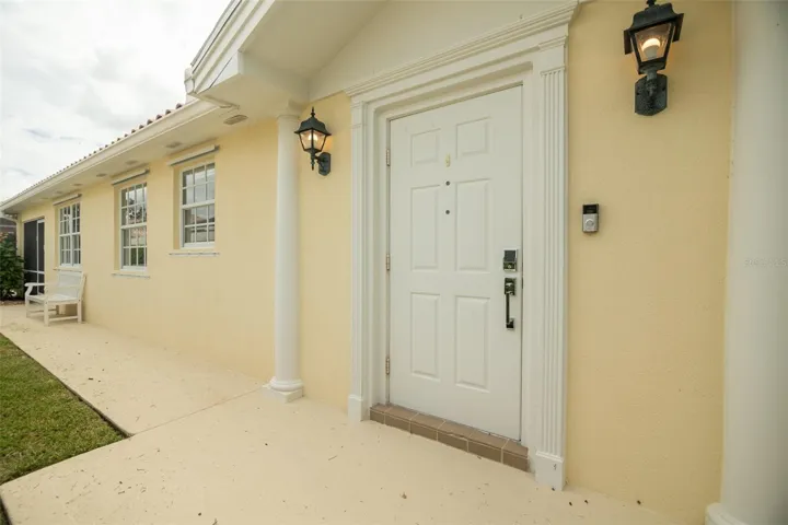 View of walk way leading to front door and beyond to the seprate pool entrance.