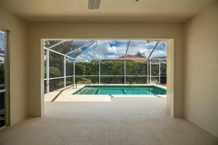 Back patio screen door on left with view of the pool in the center.