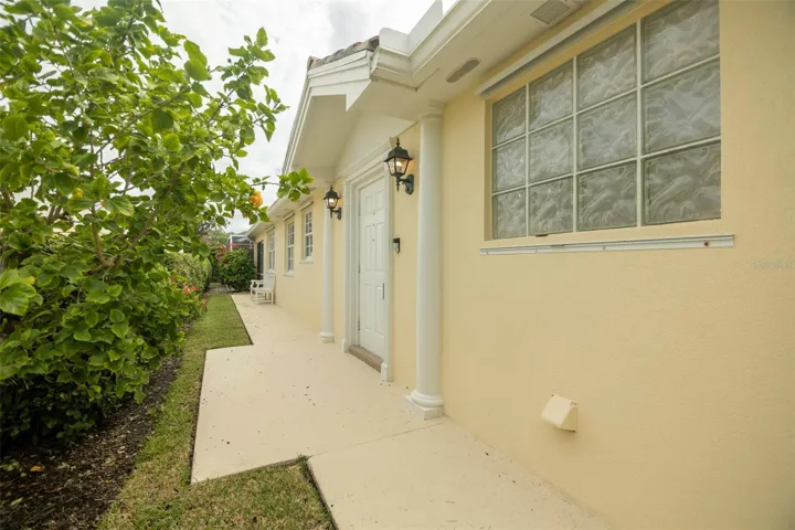 View of walk way leading to front door and beyond to the seprate pool entrance.