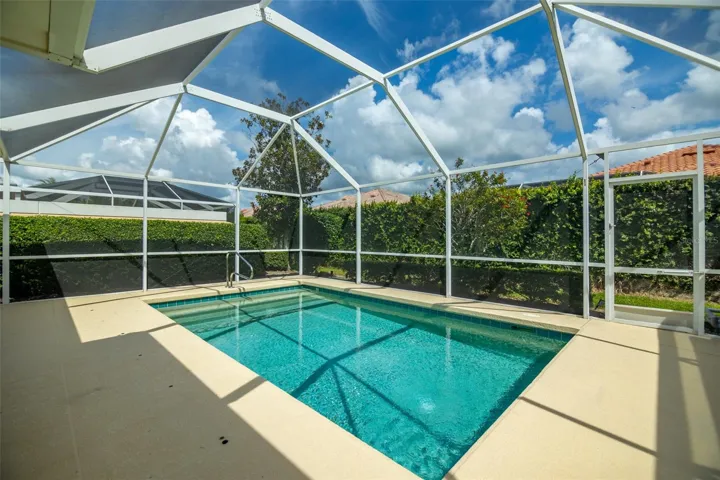 View of pool as well as another screen door at the back of the screen cage.