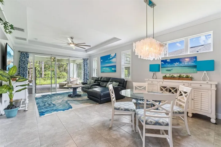 View of the Dining &amp; Great Room areas w/ crown molding, tray ceiling &amp; a ceiling fan