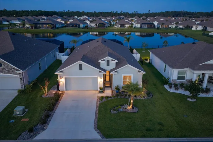 Front view of home with landscape lighting and rear, east-facing pond view.