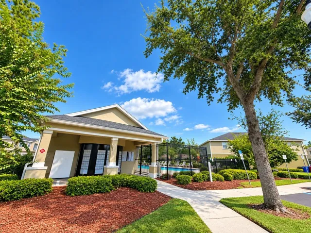 Community clubhouse surrounded by attractive landscaping.