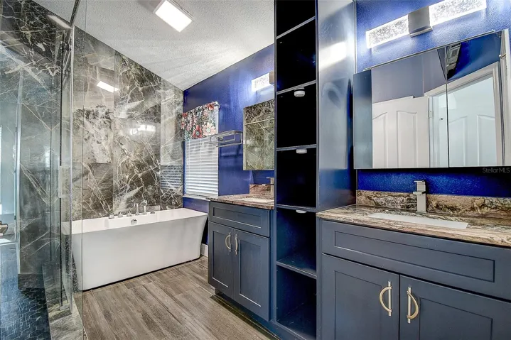 Large Spa tub and dual vanities with granite and wood cabinetry