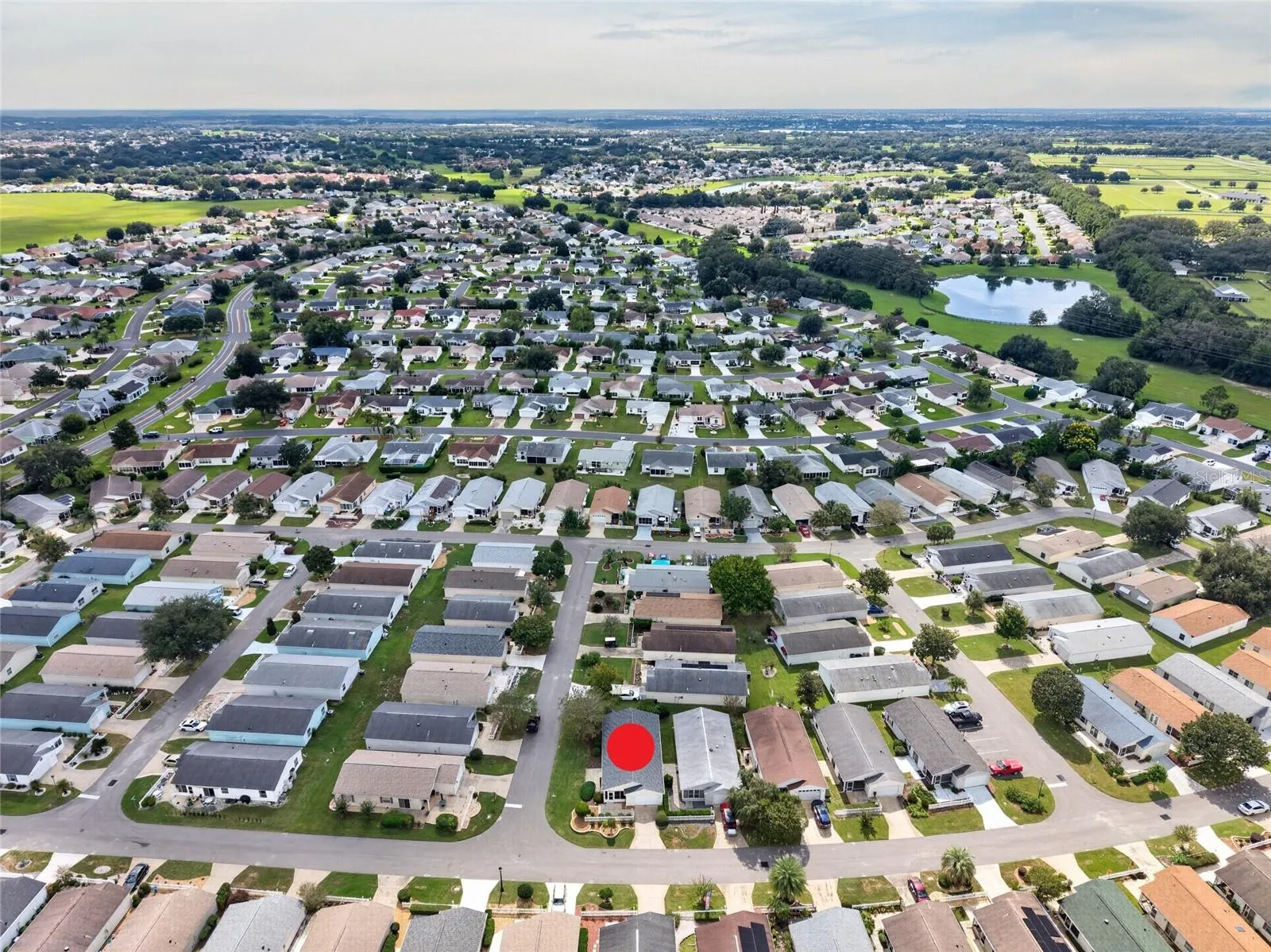 AERIAL – Looking South – CORNER LOT villa (marked) in SANTO DOMINGO, with Cazares Avenue (left), the Sharon L. Morse Owl Preserve (deep left) and golf-cart access to Lake Sumter Landing (deep center).