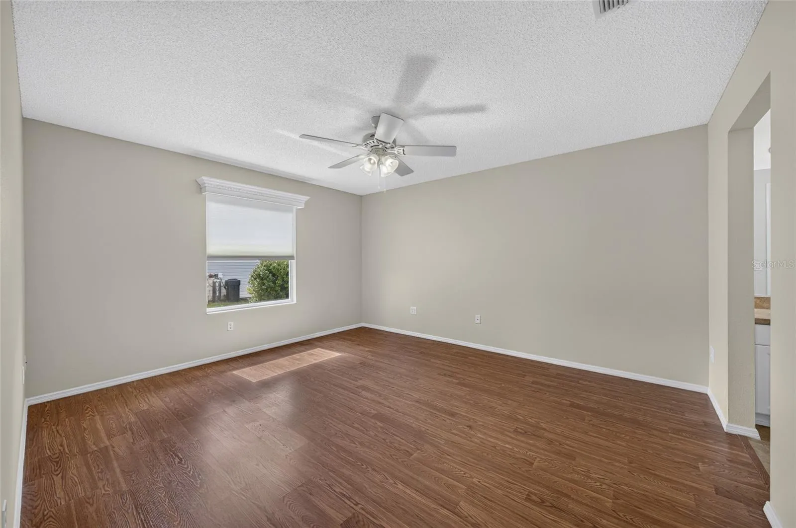 PRIMARY BEDROOM view from the doorway - Note white wooden window cornice and ceiling fan with light.