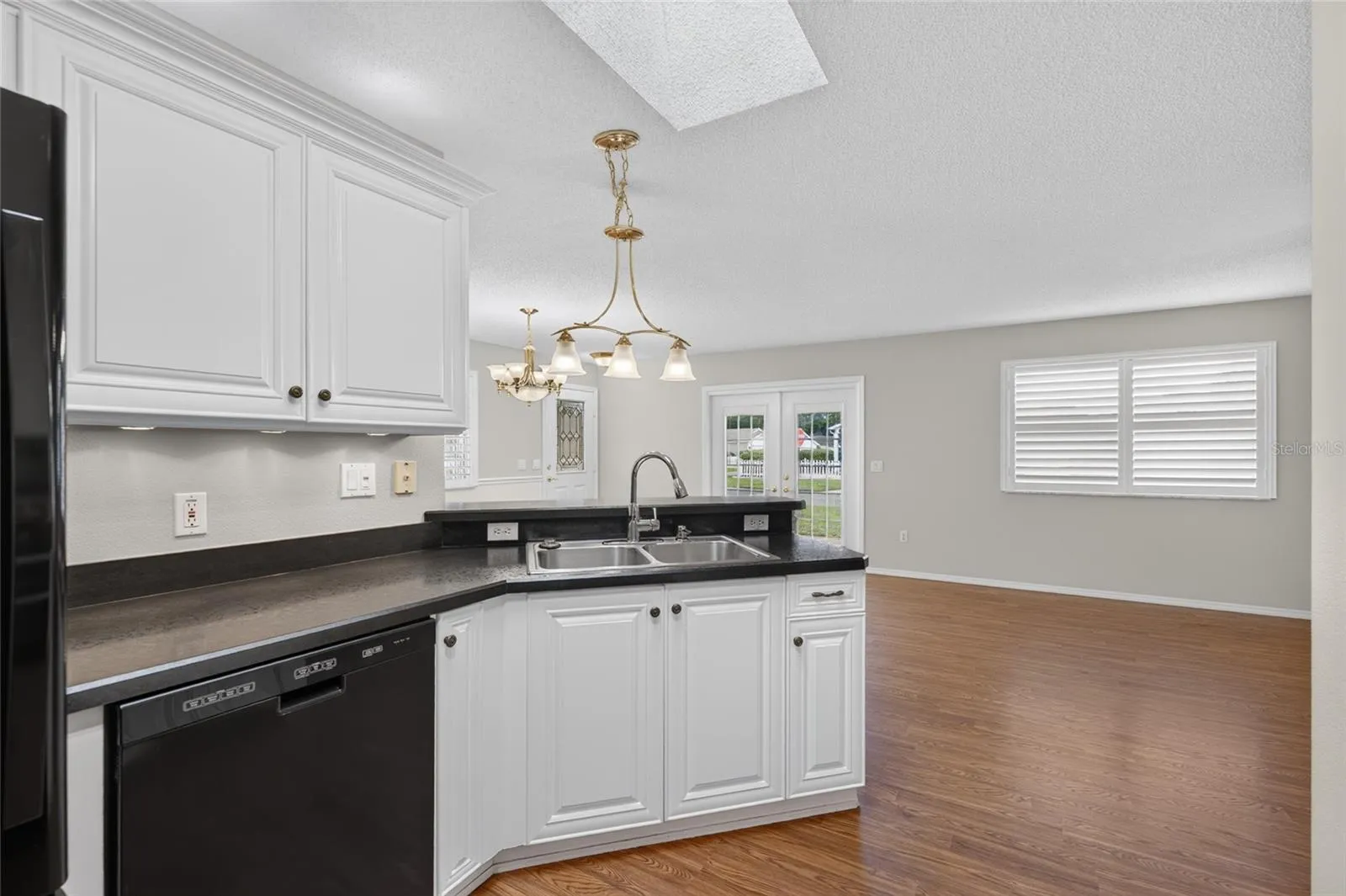 KITCHEN - View of Double sink w/ pull-down faucet (R), FRENCH DOOR REFRIGERATOR (far L) & KitchenAid DISHWASHER (center L). High-definition black laminate countertops round out this efficiently designed triangular workspace.