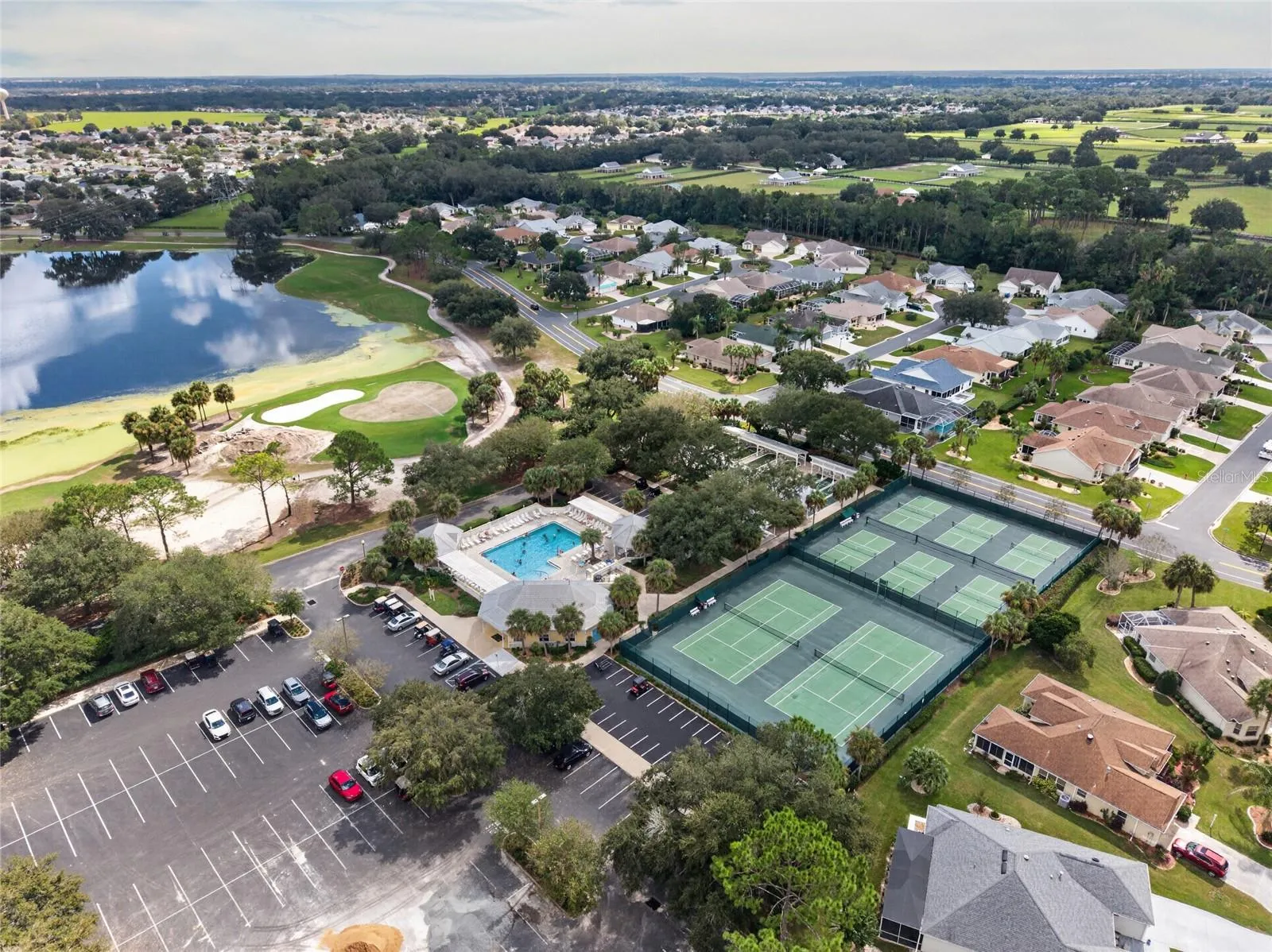 EL SANTIAGO RECREATION area / AERIAL - Overview of the community recreation grounds, with neighborhood homes and golf-course greens in the background.