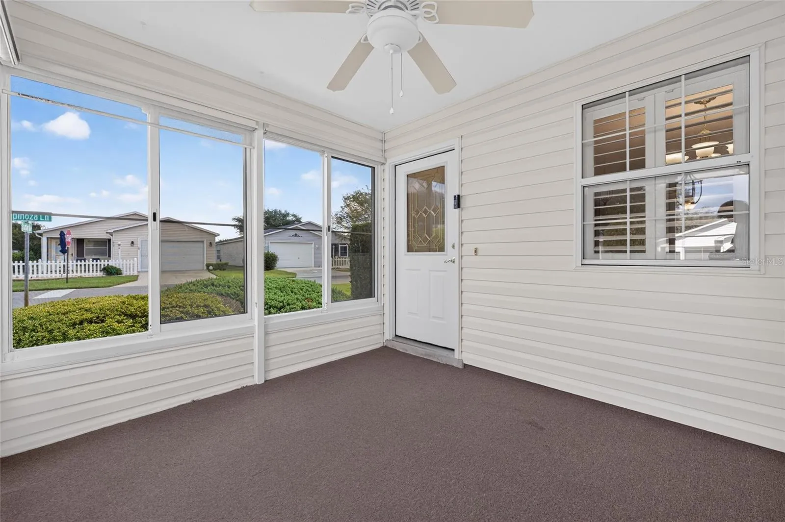 ENCLOSED LANAI / FRONT ENTRY - A half-lite front door with a DECORATIVE LEADED-GLASS INSERT design of geometric shpes, privacy glass & bright brass caming welcomes you into this lovely villa.