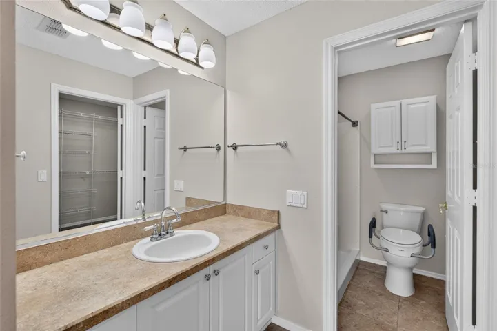 PRIMARY ENSUITE BATHROOM - View of separate comfort height toilet & WALK-IN SHOWER. Note wall cabinet above the toilet.