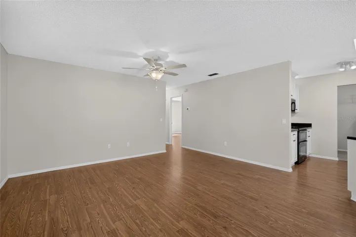 LIVING ROOM - WOOD-LOOK LAMINATE flooring in the main living area, KITCHEN visible on R.