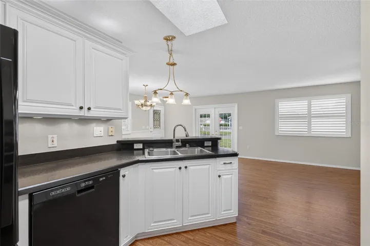KITCHEN - View of Double sink w/ pull-down faucet (R), FRENCH DOOR REFRIGERATOR (far L) & KitchenAid DISHWASHER (center L). High-definition black laminate countertops round out this efficiently designed triangular workspace.
