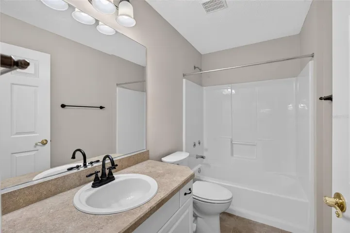BATHROOM #2 - View of TUB/SHOWER COMBO, comfort-height toilet and single-sink vanity with mirror.