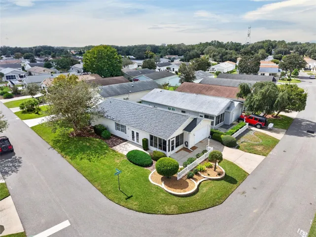 AERIAL VIEW / CORNER LOT - Low aerial view of the villa's CORNER LOT, driveway, front landscaping and adjoining streets.
