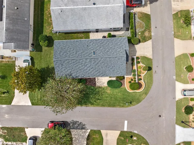 OVERHEAD AERIAL - Top-down view of the ARCH SHINGLE ROOF (2025) and the villa's footprint on a corner lot between the adjoining streets.
