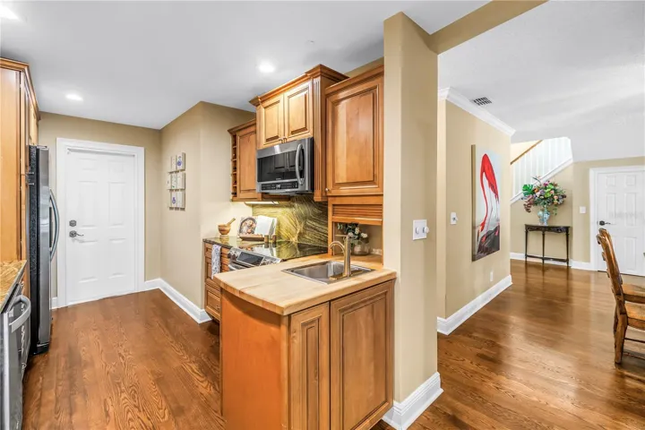 The kitchen features an efficient workspace equipped with a range, a convection microwave, and a preparation sink with an integrated butcher block countertop.