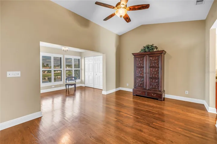 Spacious primary bedroom featuring vaulted ceilings and an elegantly enclosed porch with two additional closets. This room offers magnificent lake views and provides an ideal space for a home gym, a quiet reading nook, or a nursery.