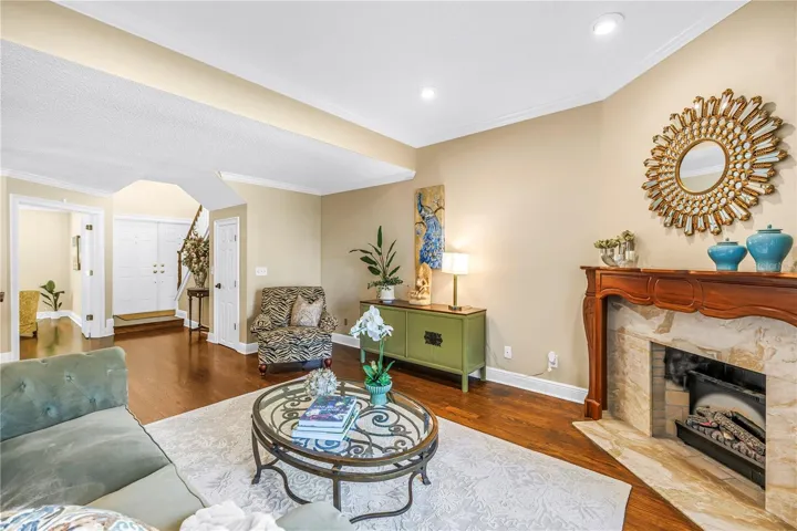 The open formal living area provides an ideal entry for guests, featuring panoramic lake views and an elegant marble fireplace.
