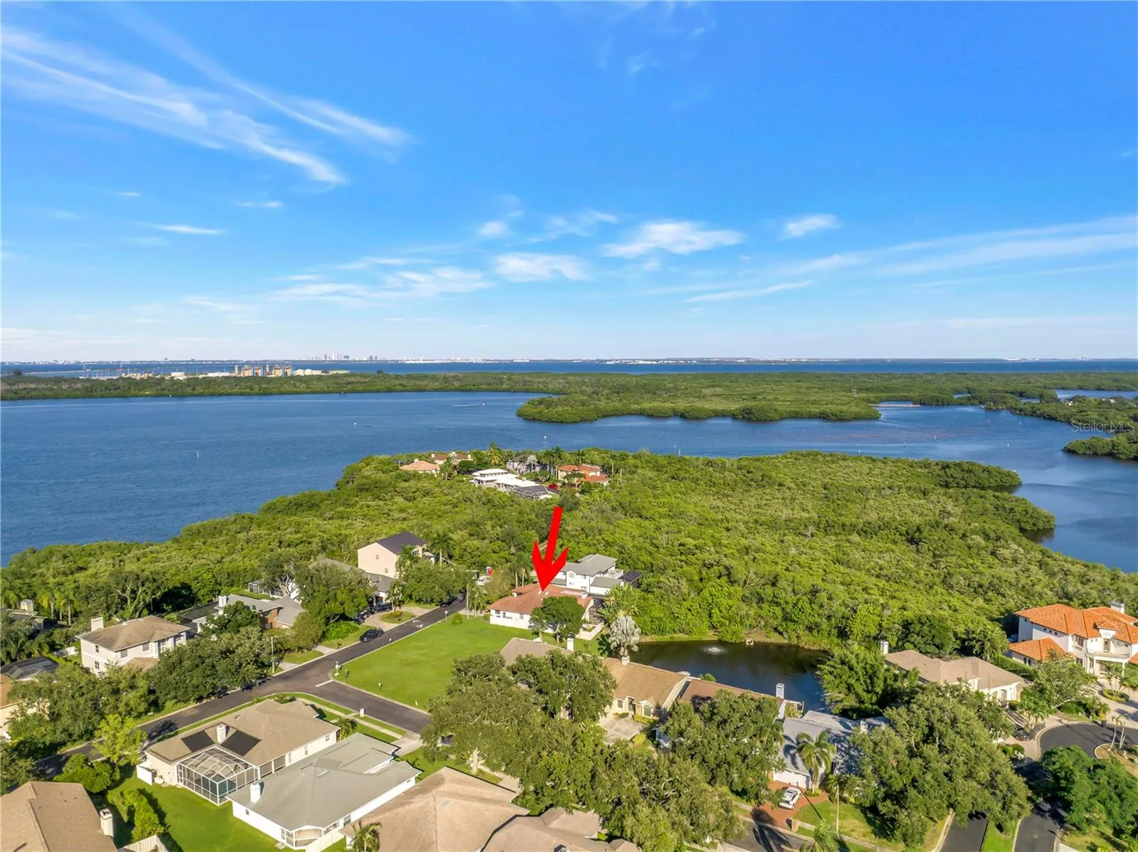 Captures a scenic view of Riviera Bay looking north, with the City of Tampa visible in the distance. This home is ideally situated for easy commuting, offering convenient access to downtown Tampa in approximately 15 minutes.