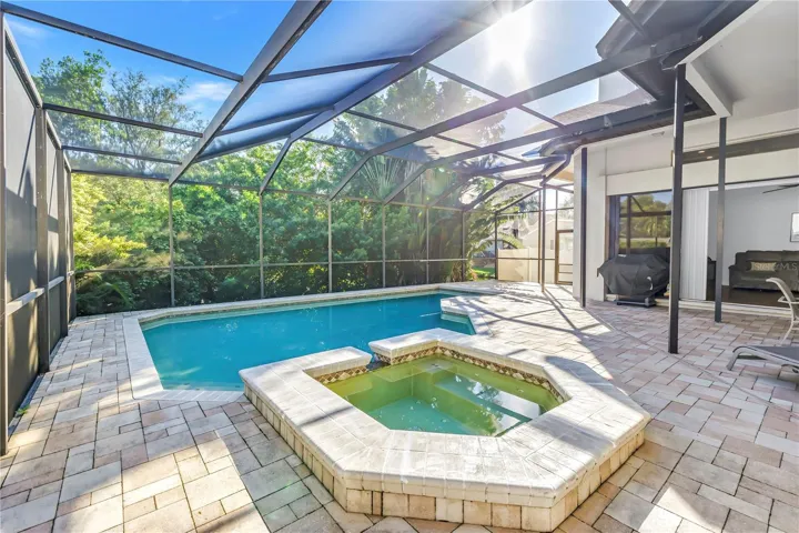 This property features a propane-heated hot tub and a spacious pool, all fully enclosed and protected by a massive screened lanai, creating a true luxury oasis.