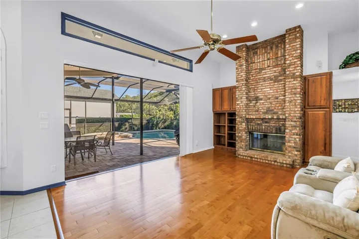 Current photo of triple pocketed 8-Ft sliders with view to the pool and wood burning fireplace