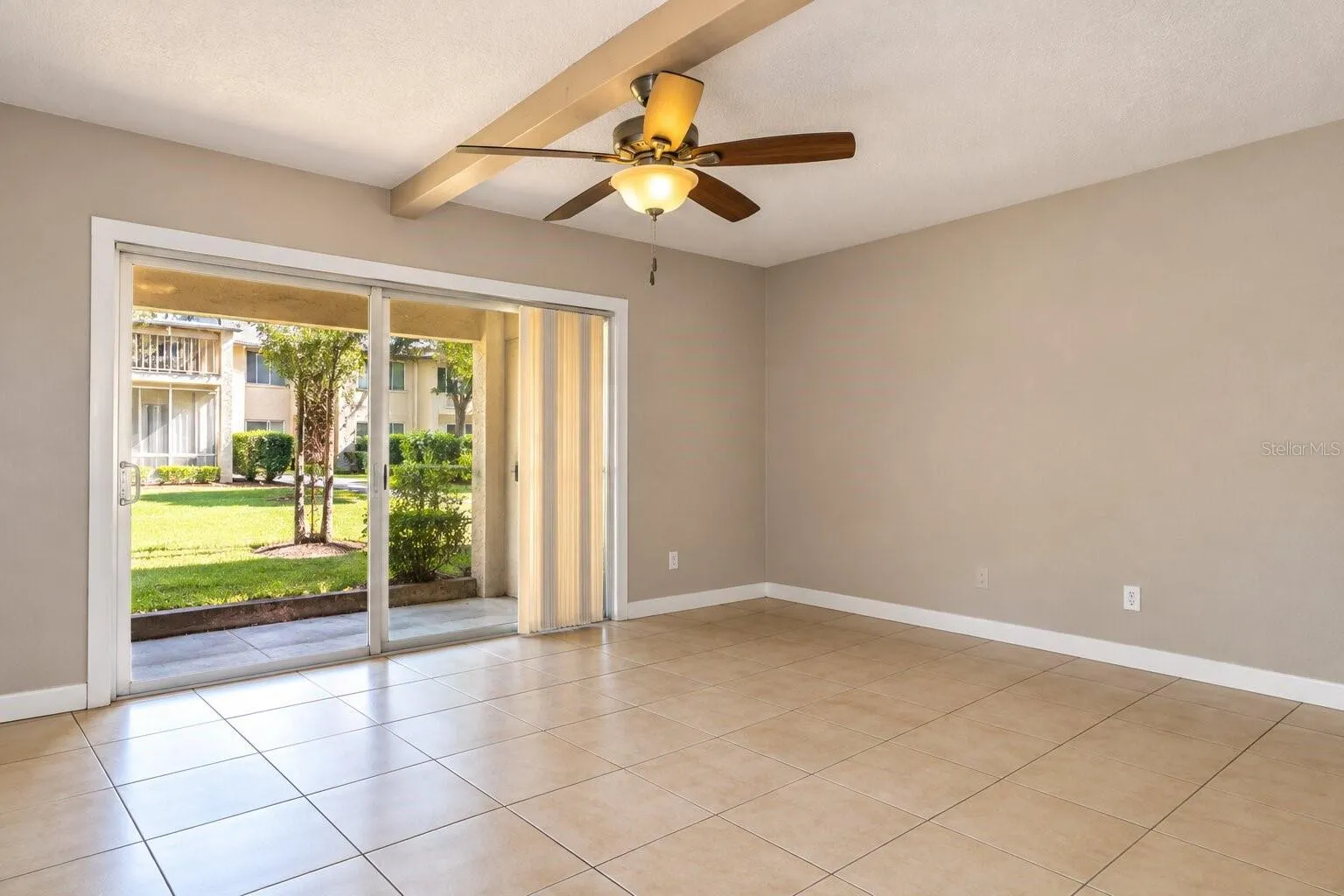 Spacious living area with tile flooring and patio access