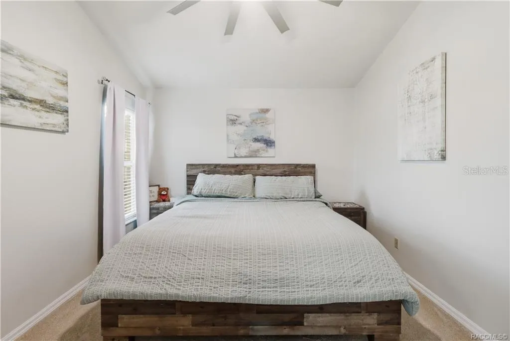 Primary Bedroom – Comfortable primary suite featuring vaulted ceilings, a ceiling fan, neutral finishes.
