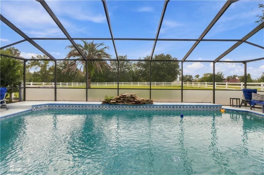 Screen-Enclosed Pool – Enjoy the ELECTRIC-HEATED CHLORINE POOL featuring a decorative waterfall & views of the spacious backyard.