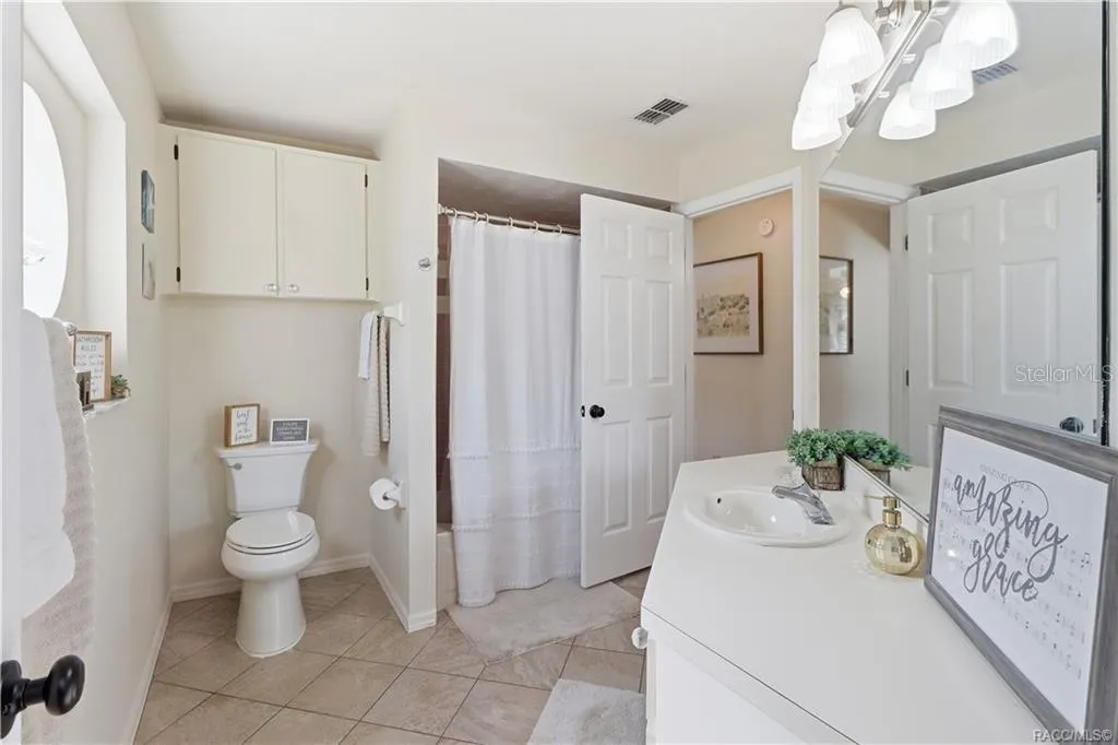 Guest Bathroom – Clean, inviting guest bathroom featuring a tub/shower combination, tile flooring, vanity & additional storage cabinetry.