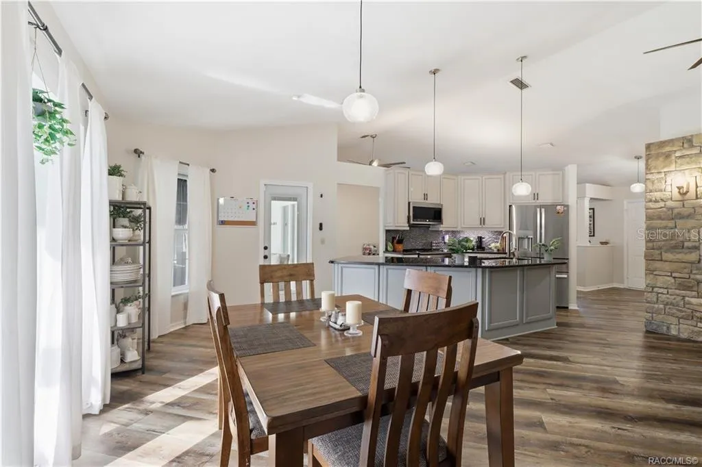 DINING AREA & KITCHEN- Inviting dining area w/natural light, easy access to the pool area & an open connection to the updated kitchen.