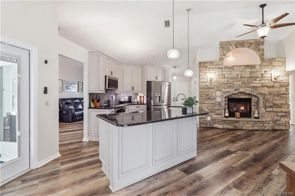 UPDATED KITCHENAttractive kitchen featuring GRANITE COUNTERTOPS, center island, newer stainless steel appliances, pendant lighting & abundant cabinetry.