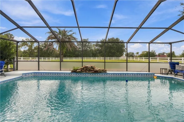 Screen-Enclosed Pool – Enjoy the ELECTRIC-HEATED CHLORINE POOL featuring a decorative waterfall & views of the spacious backyard.