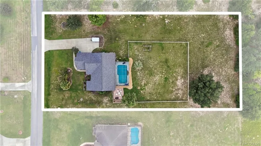 Bird's-eye view showcasing the spacious 1.02-acre homesite, screened-in pool, white rail-fenced backyard & outdoor living areas.