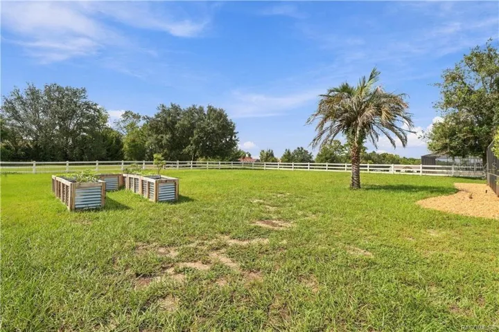 Backyard & Garden Area – Enjoy the wide-open backyard featuring attractive WHITE RAIL FENCING, raised garden beds & a palm tree. Plenty of room to enjoy gardening, outdoor activities or simply relaxing in the Florida sunshine!