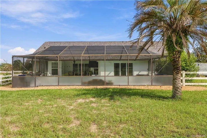 Rear Exterior – Expansive screen enclosure overlooking the backyard, offering plenty of space to enjoy Florida's outdoor lifestyle.