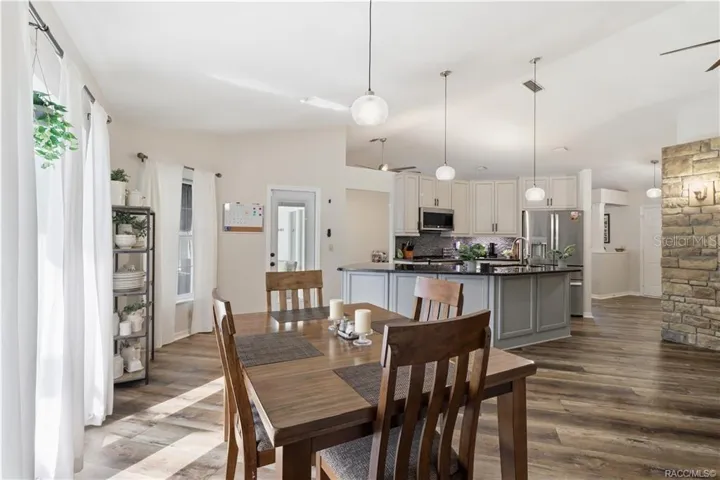 DINING AREA & KITCHEN- Inviting dining area w/natural light, easy access to the pool area & an open connection to the updated kitchen.