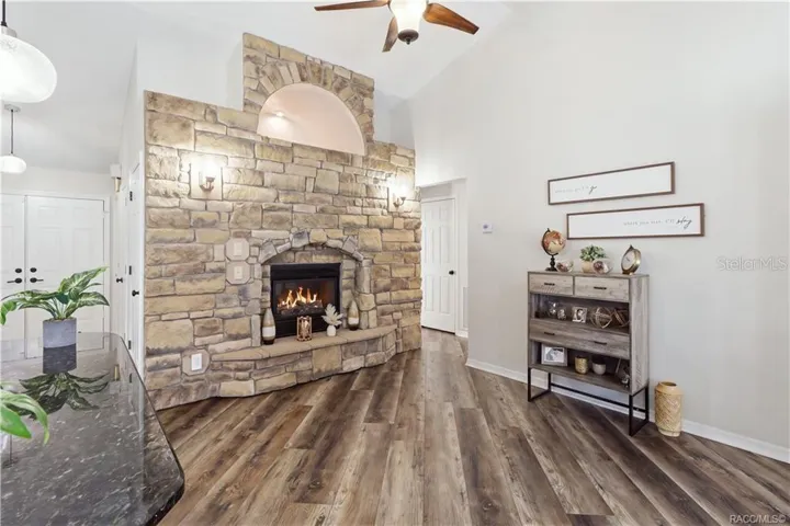 STONE-ACCENTED FIREPLACE- Impressive floor-to-ceiling stone-accented electric fireplace featuring a decorative arched opening & built-in hearth.