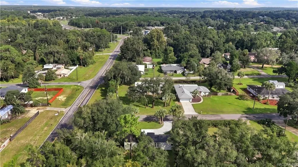 Aerial Neighborhood View – Elevated view highlighting the home's corner setting, surrounding residential neighborhood, mature trees &amp; nearby roadways.