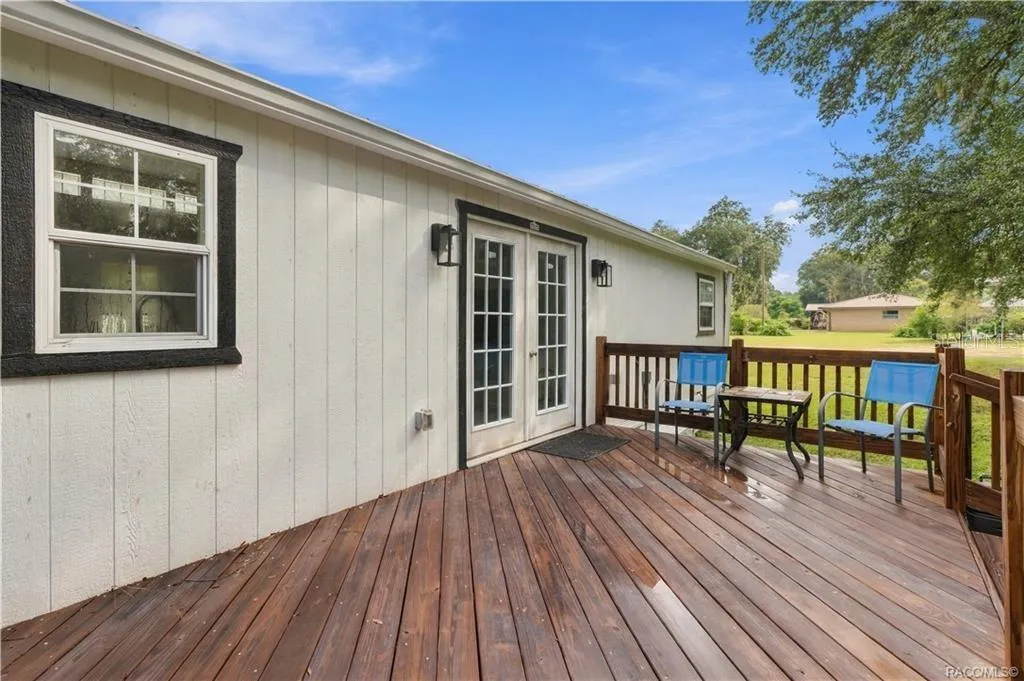 Outdoor Living – Another view of the rear deck showcasing its open layout, wooden railings &amp; easy access to the backyard. A great setting for enjoying Florida's beautiful weather!