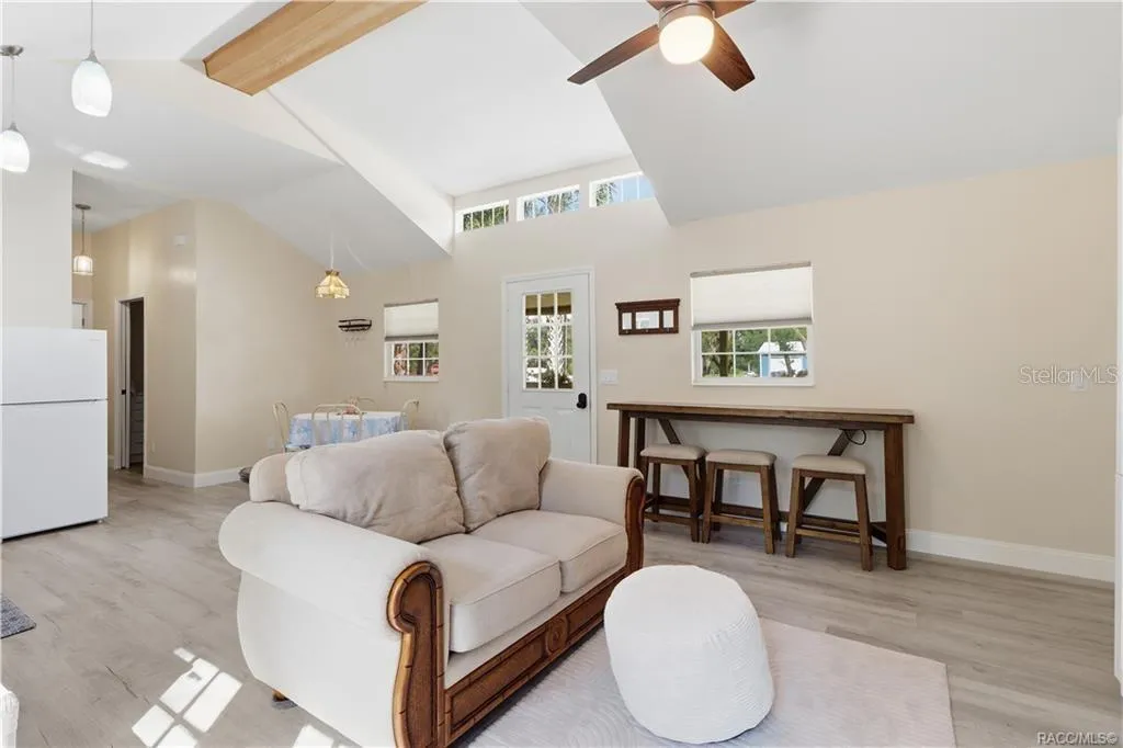 Open Floor Plan – Natural light fills this cheerful living space featuring VAULTED CEILINGS, decorative wood beam, clerestory windows &amp; a convenient breakfast bar area. An inviting place to relax or gather!
