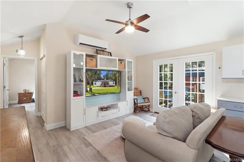 Open Living Area – Another beautiful view of the comfortable living room, showcasing the open layout, attractive furnishings, w/ entertainment center &amp; French doors leading outdoors.