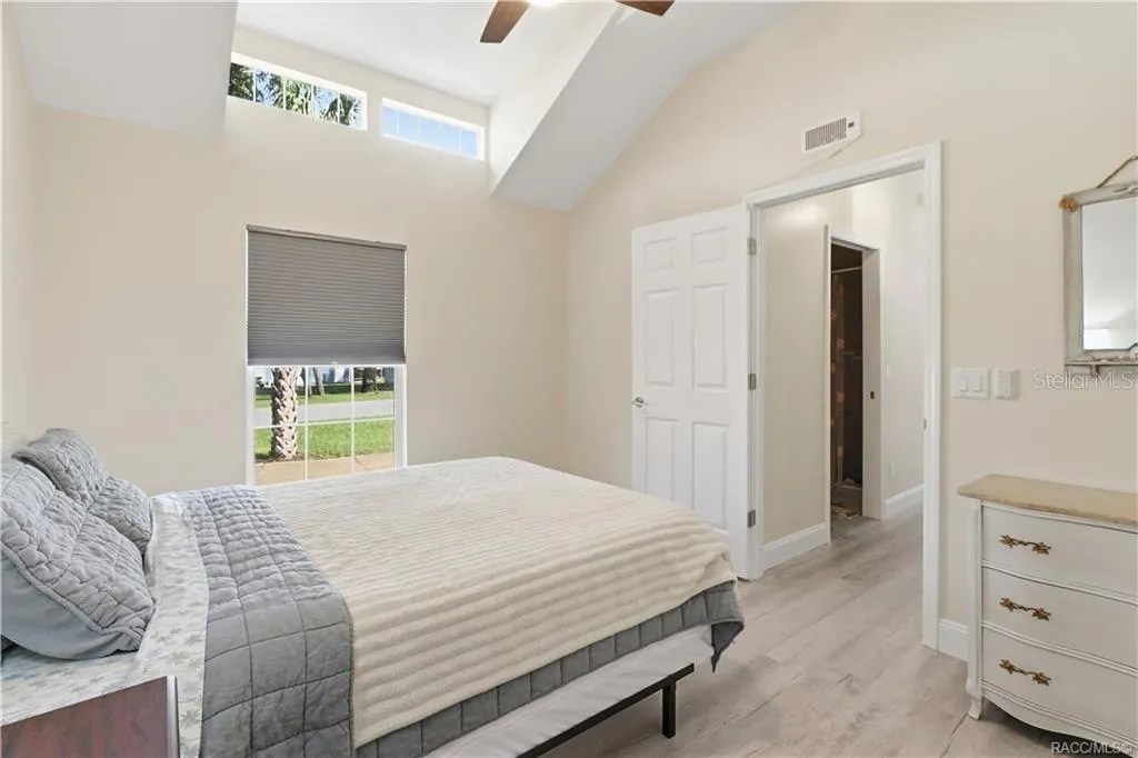 Bedroom – Comfortable bedroom featuring VAULTED CEILINGS, luxury vinyl plank flooring, ceiling fan, spacious double closets &amp; attractive furnishings.