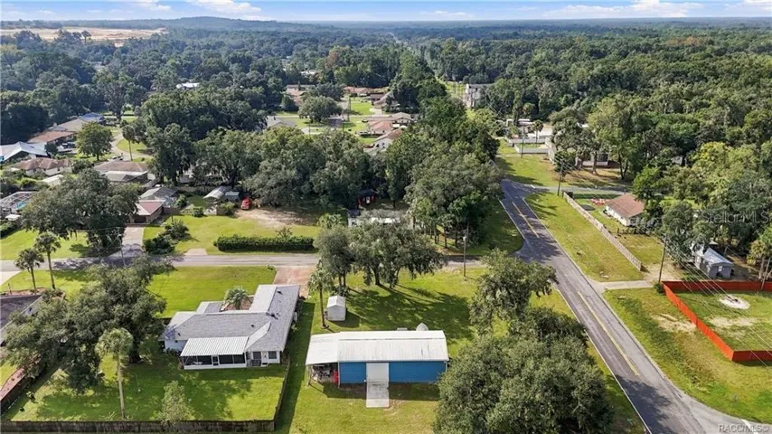 Neighborhood Aerial View – Wide aerial perspective capturing the surrounding neighborhood, tree-lined streets &amp; established residential setting.
