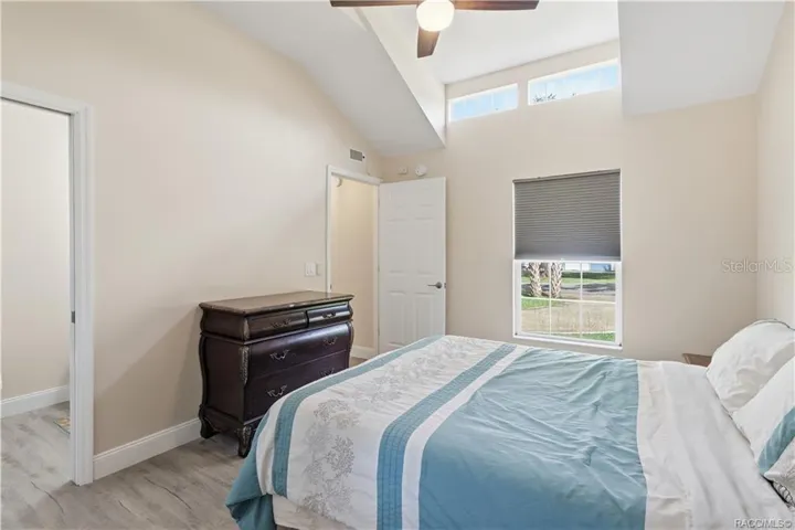 Primary Bedroom – Another view of the cheerful bedroom showcasing its VAULTED CEILINGS, upper transom windows, natural light &amp; comfortable layout.