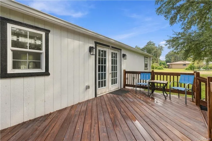 Outdoor Living – Another view of the rear deck showcasing its open layout, wooden railings &amp; easy access to the backyard. A great setting for enjoying Florida's beautiful weather!