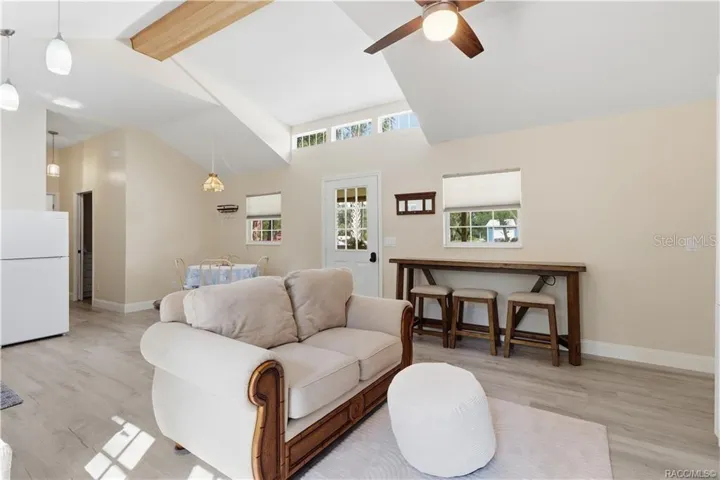 Open Floor Plan – Natural light fills this cheerful living space featuring VAULTED CEILINGS, decorative wood beam, clerestory windows &amp; a convenient breakfast bar area. An inviting place to relax or gather!