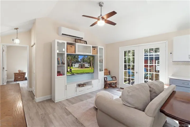Open Living Area – Another beautiful view of the comfortable living room, showcasing the open layout, attractive furnishings, w/ entertainment center &amp; French doors leading outdoors.